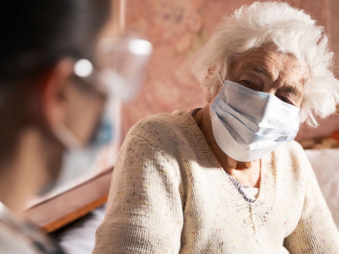 older woman sitting with healthcare worker