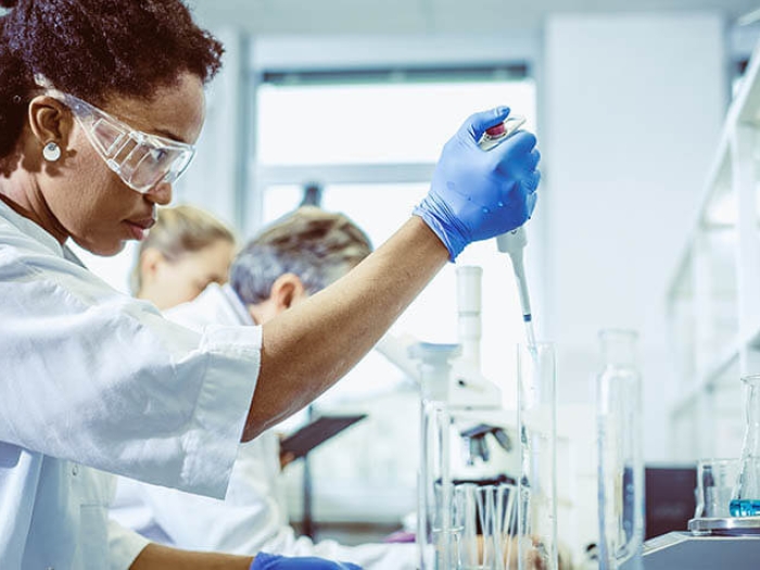 Femal doctor using a pipette in lab