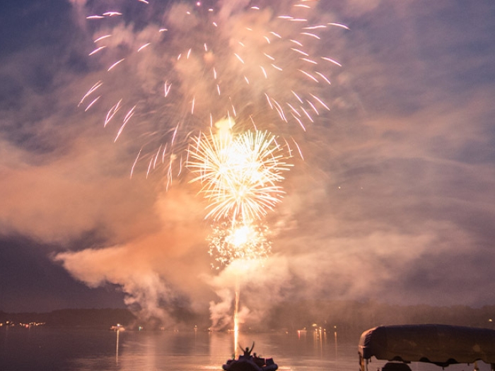 fireworks over the lake in dark blue night sky and fireworks bright orange
