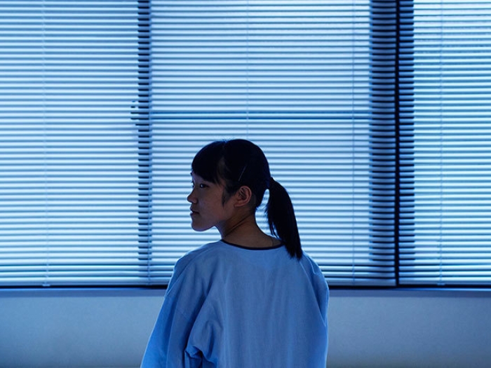 girl in room looking back grey