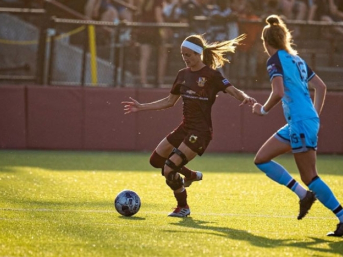 girls playing soccer blue red on field
