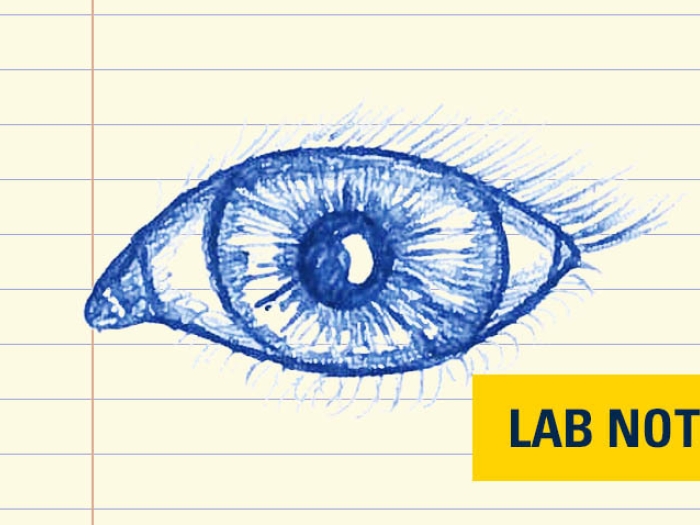 drawing in blue ink on lined paper of eye with lab note badge written out in yellow and navy blue bottom right corner