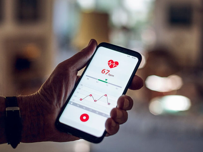 Man holding cell phone with heart rate app showing