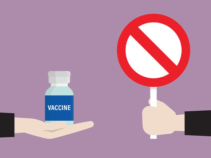 Hand holding stop symbol and a hand holding vaccine pill bottle.