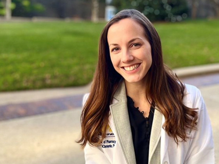 woman smiling white coat green grass