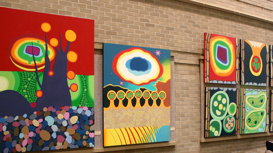 A brick wall with colorful art exhibits