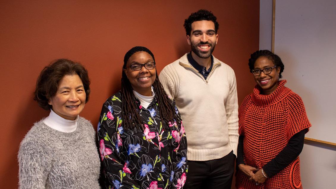 Multi ethnic group of people smiling and posing for a photograph.