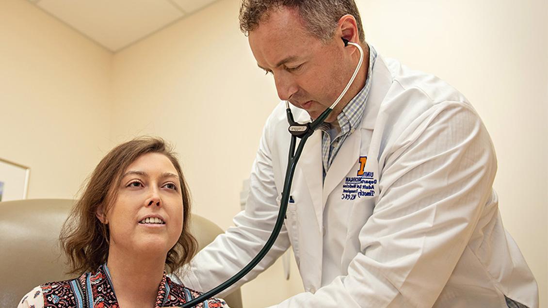 Doctor checking heart of woman