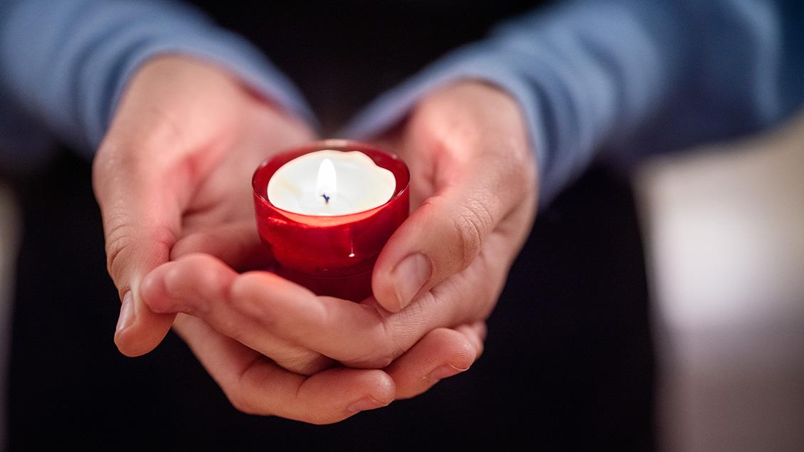 close up of woman holding a votive candle