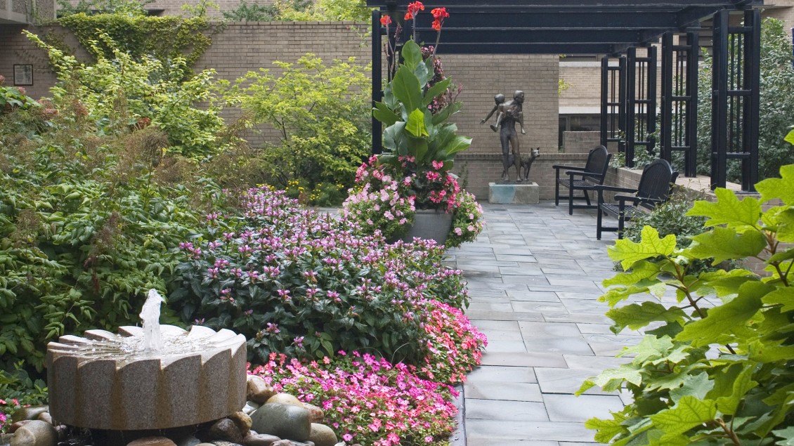 Garden with with fountain and paved pathway leading up to sculpture