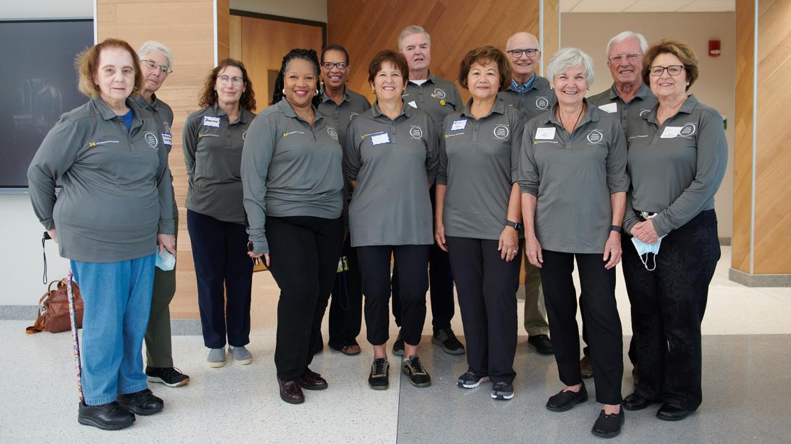 OLLI team members in gray shirt smile for a photograph.