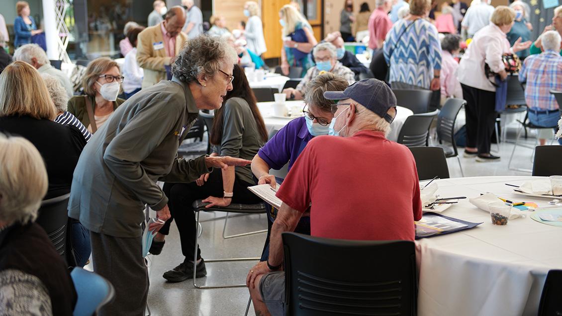 Group of elderly people discussing and taking notes.