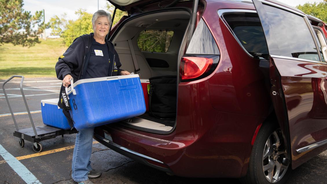 Volunteer delivering food to elderly woman