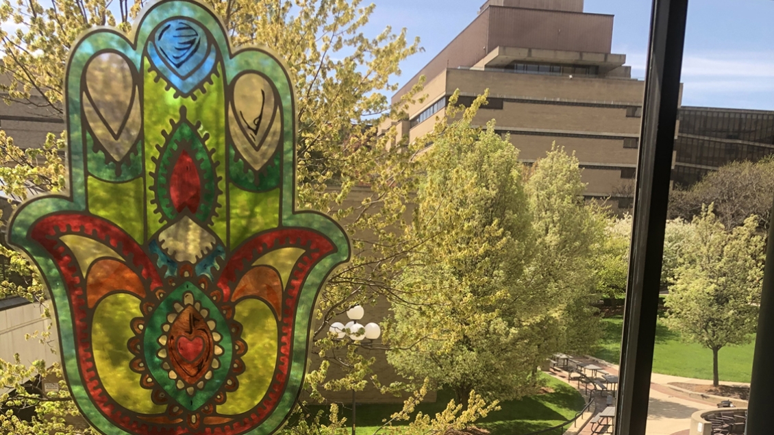 Sun shines through a colorful Hamsa Hands window decal