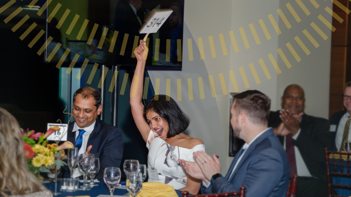 Woman raising auction paddle at Vita Redita event