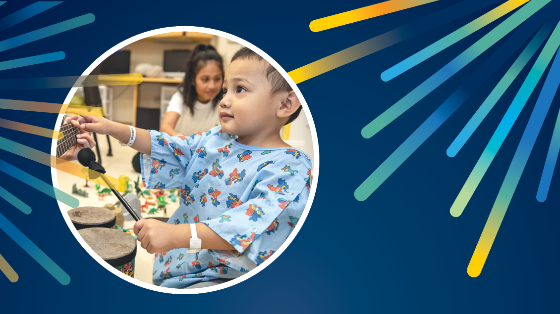 Toddler boy in hospital gown on a blue background with colorful illustrated sunbursts