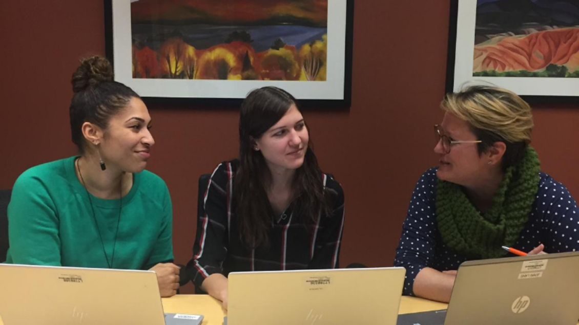 A picture of three AHI employees engaged in conversation