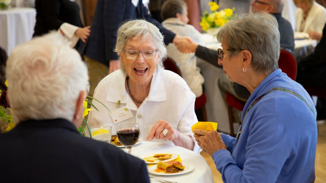 Big Hearts for Seniors attendees enjoying snacks and conversation at a round table