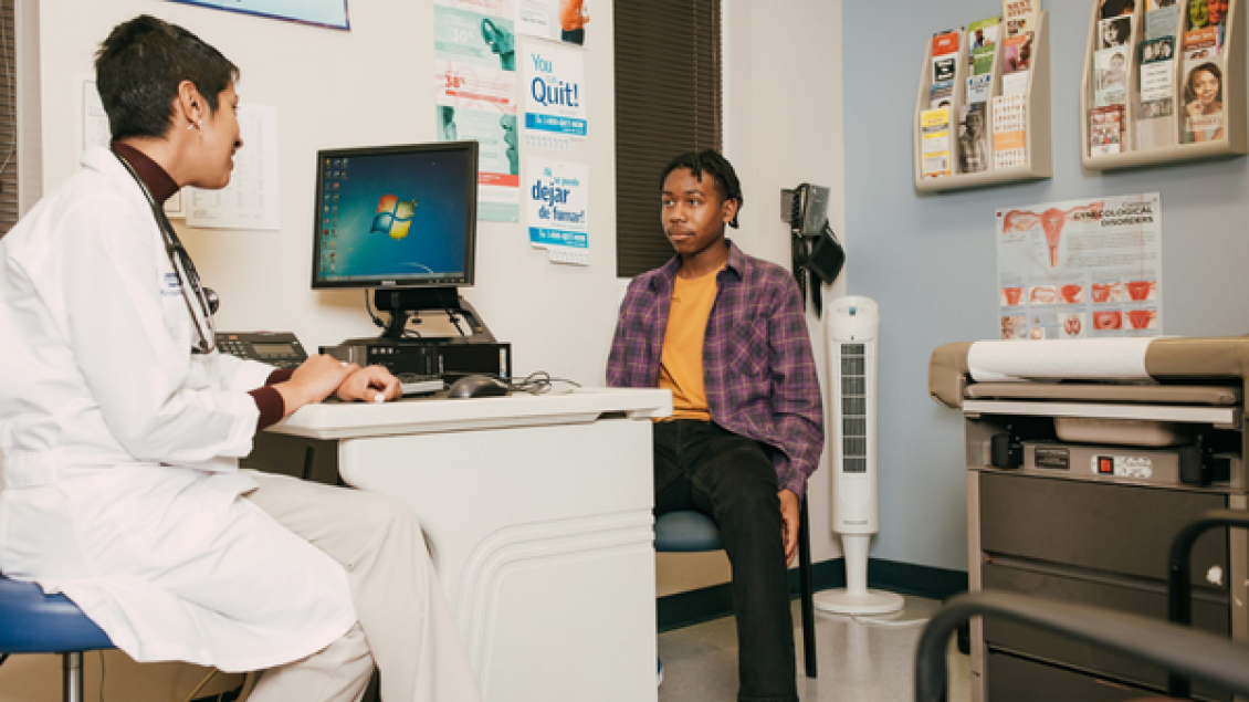 A doctor talking to a young patient.