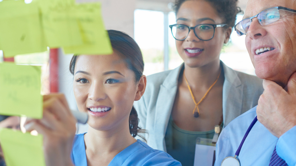 Group of medical professionals looking at sticky notes.