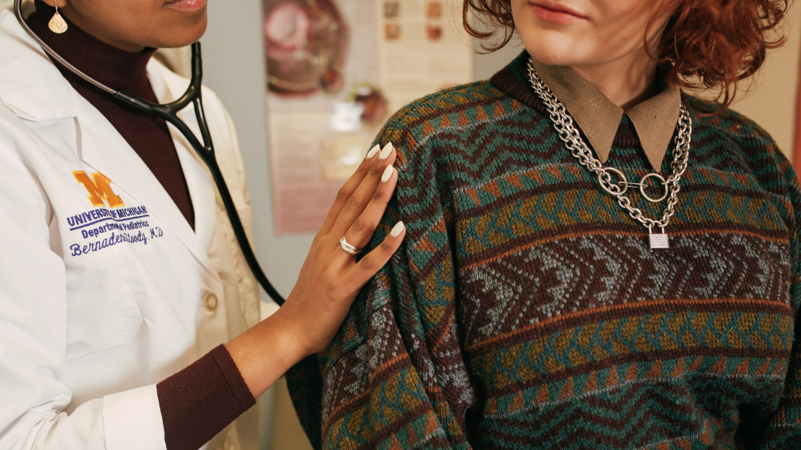 physician listens to teen patient's heartbeat
