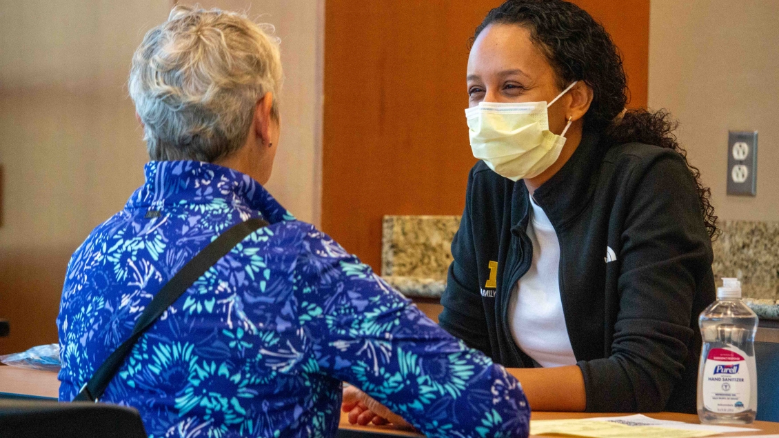 Female volunteer helps at flu clinic table