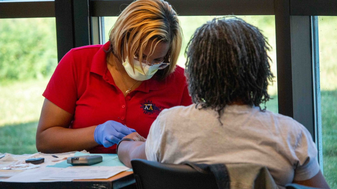 Female staff member checks a patient in for flu shot