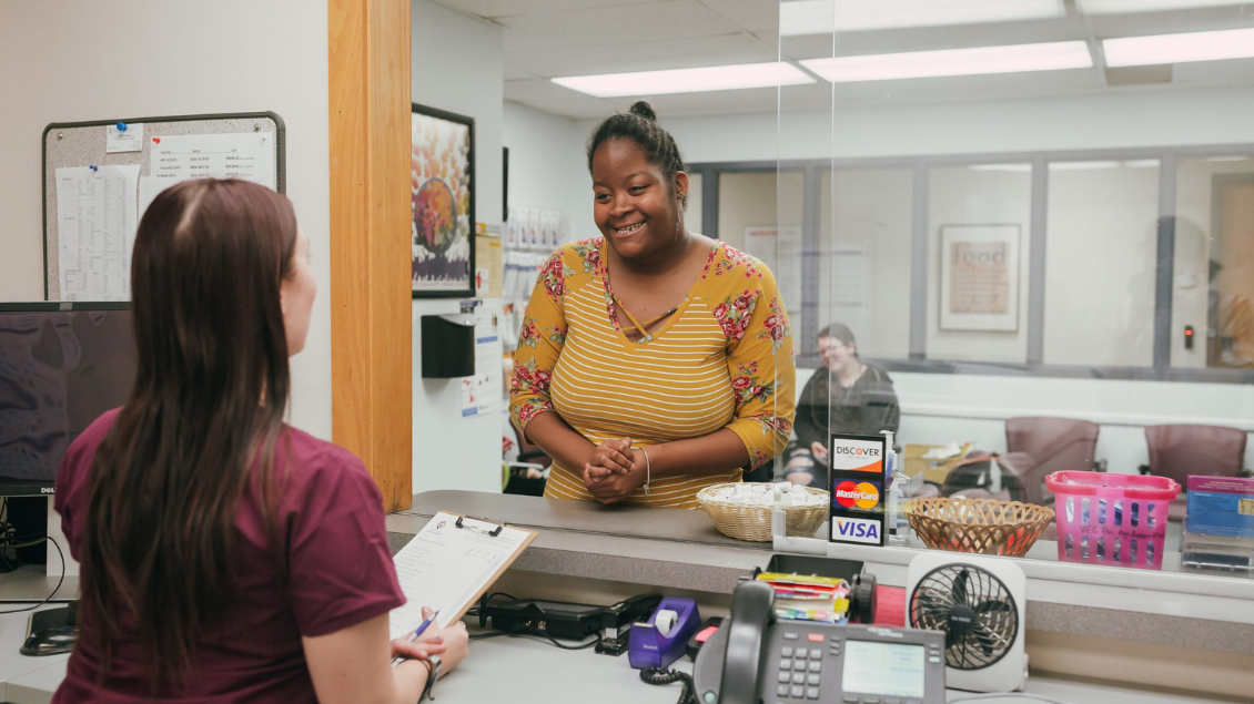 woman speaks with healthcare receptionist