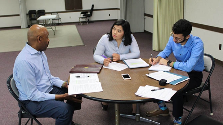 Group of people discussing and writing notes.